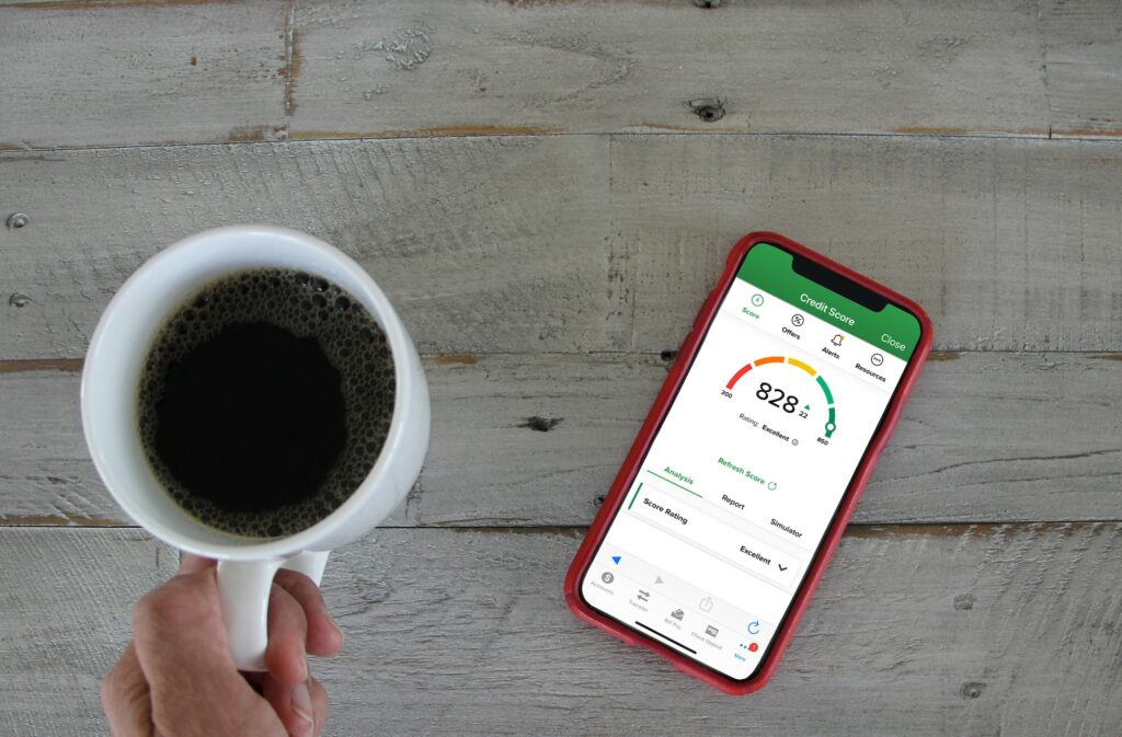 Person checking Credit Score on bank app in mobile device while drinking coffee in the morning