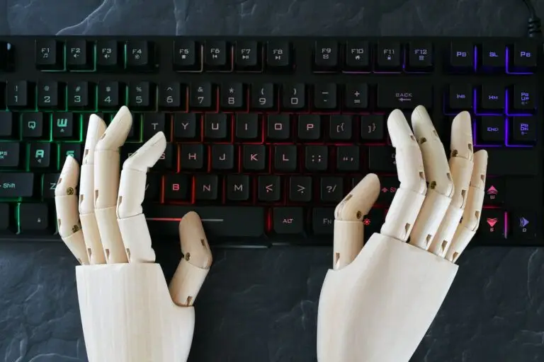 AI artificial intelligence concept - robot hands typing on lit keyboard